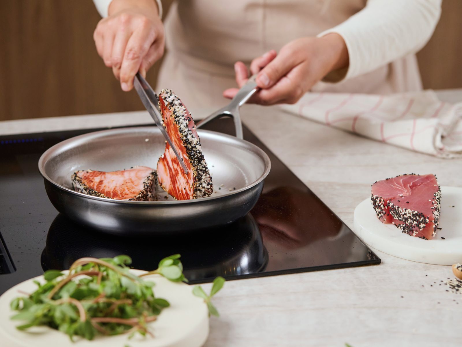 Tonijnsteak die wordt omgedraaid in een roestvrijstalen pan