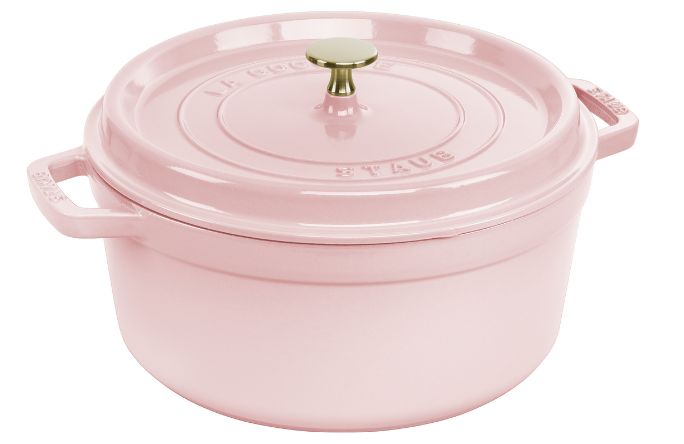 A pink cast iron Dutch oven with a lid and a brass knob, featuring side handles for easy lifting.