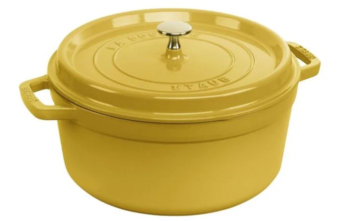 A yellow cast iron Dutch oven with a lid and a silver knob on top.